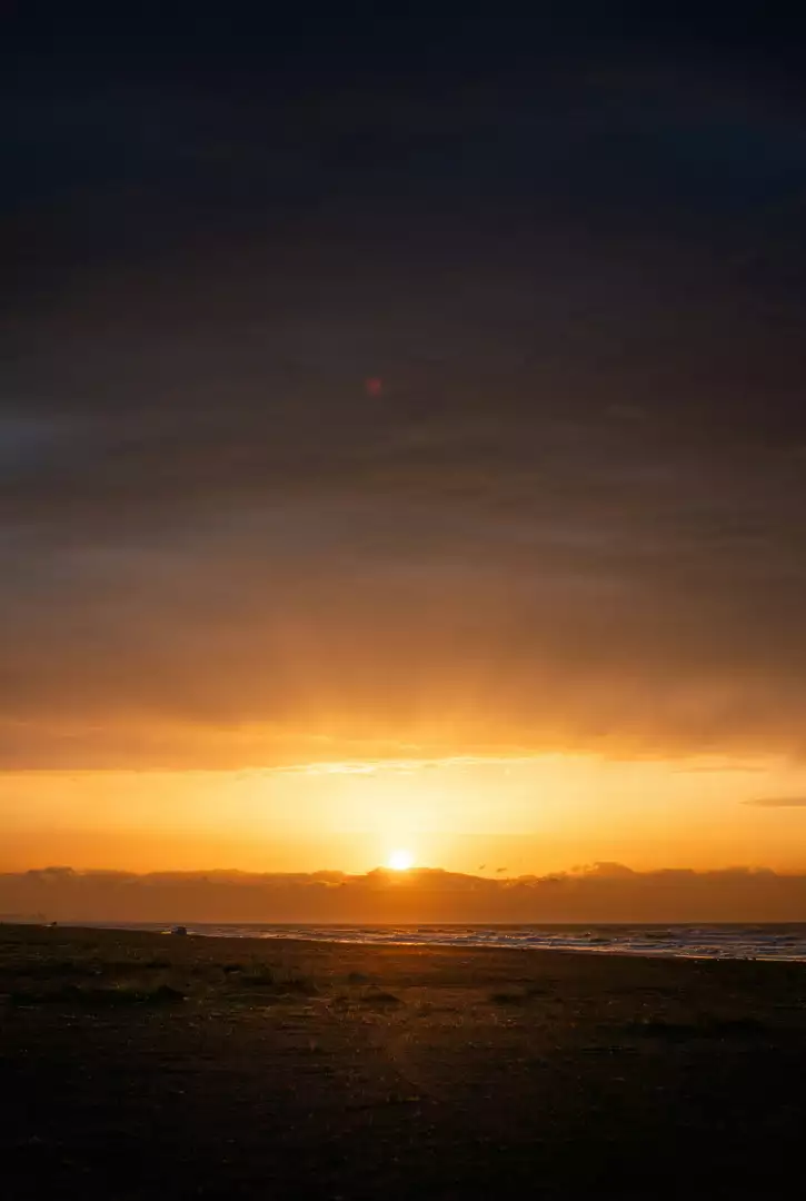 Free Premium Stock Photos Dramatic Sunset Over Beach with Ocean Waves and Distant Ships