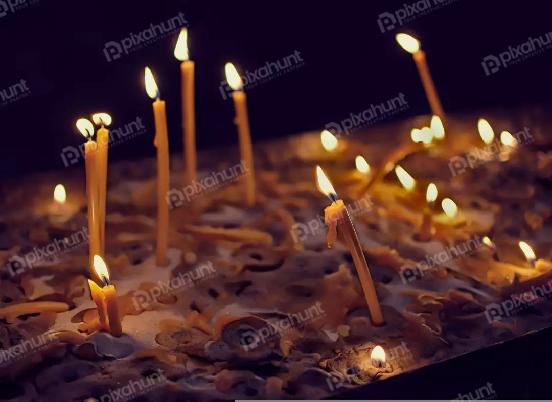 Glowing Prayer Candles Illuminating a Dark Sacred Space with Melted Wax