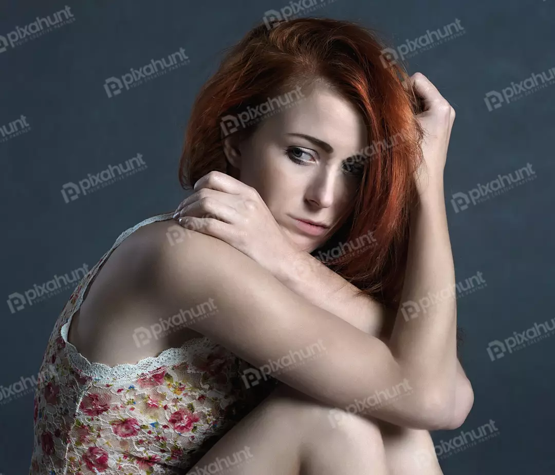 Pensive Redhead Woman in Floral Lace Top with Emotional Gaze on Dark Background