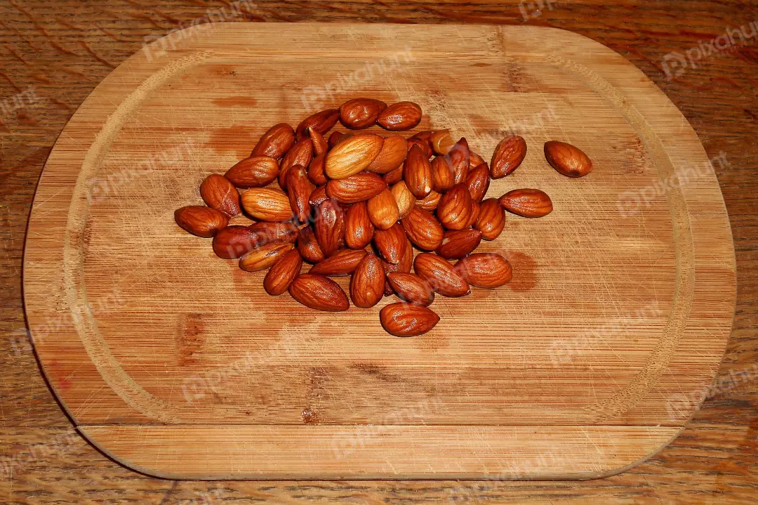 Pile of Golden Roasted Almonds on Rustic Wood Cutting Board