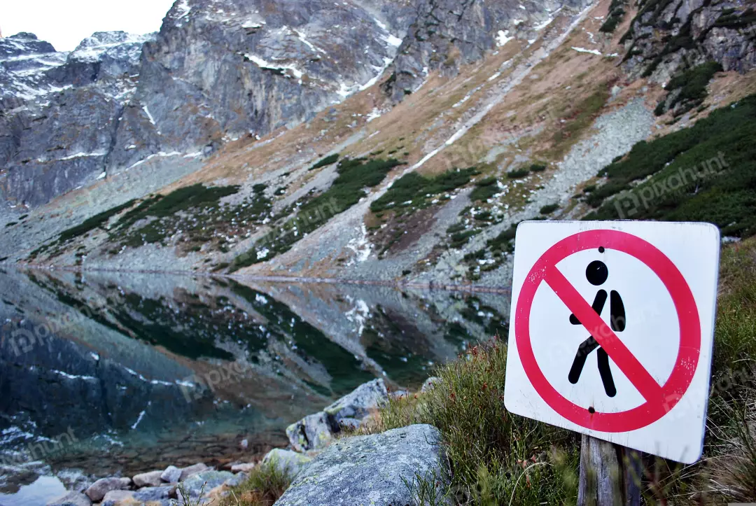 Serene Mountain Lake View with No Entry Sign in Rugged Alpine Landscape