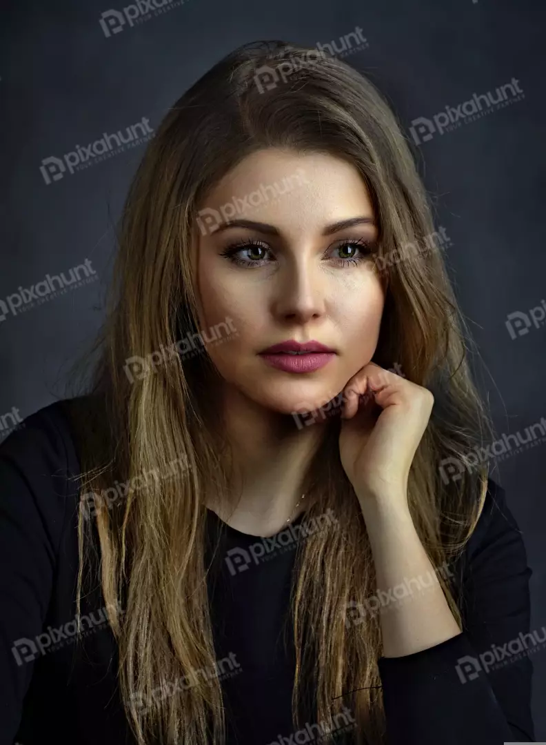 Pensive Young Woman with Long Wavy Hair and Hand on Chin Portrait