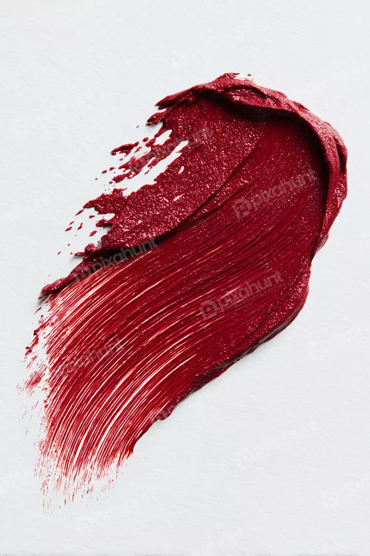 Vibrant Red Cosmetic Swatch with Glitter on Textured White Background