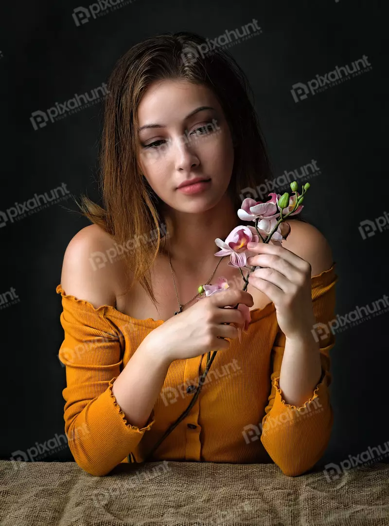 Pensive Young Woman with Delicate Orchid Flowers
