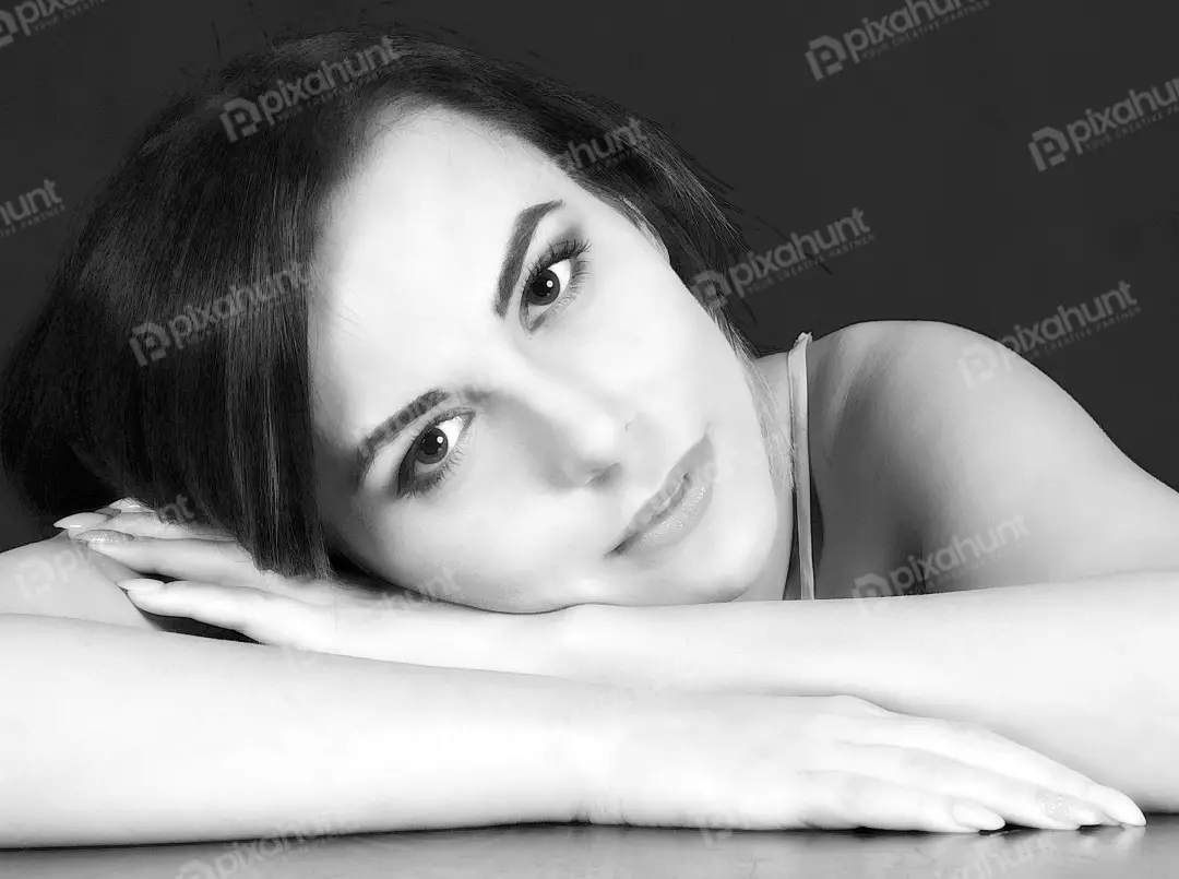 Black and White Portrait of a Thoughtful Young Woman Resting Head on Arms