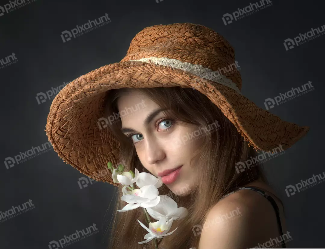 Young Woman in Straw Hat Gazing with Blue Eyes and White Orchid