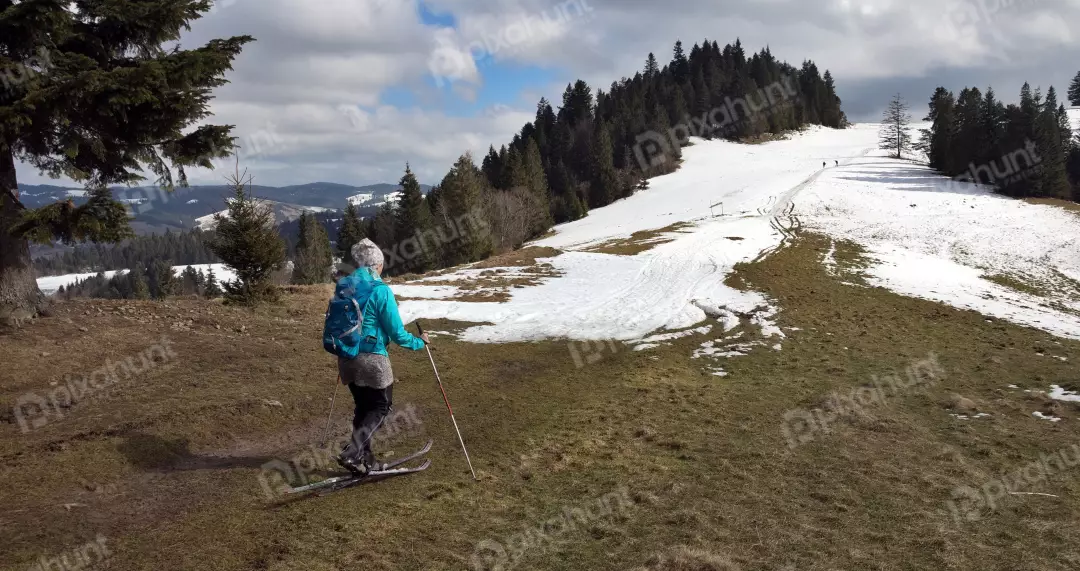 Woman Cross-Country Skiing on Snowy Mountain Slope in Early Spring