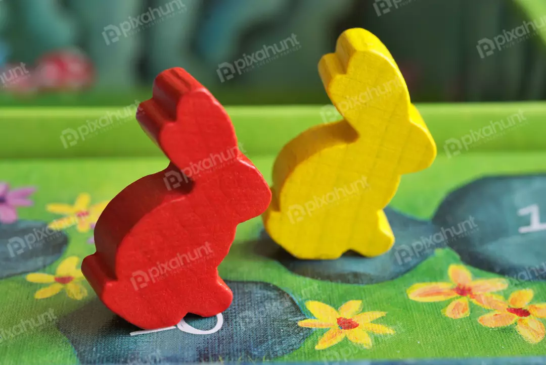 Vibrant Red and Yellow Wooden Rabbit Tokens on a Colorful Board Game