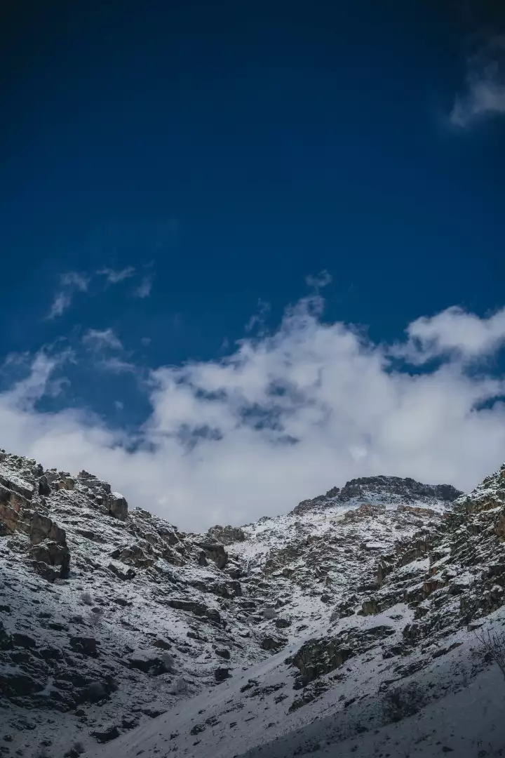 Free Premium Stock Photos Snow-covered rocky mountains under a vast blue sky with clouds