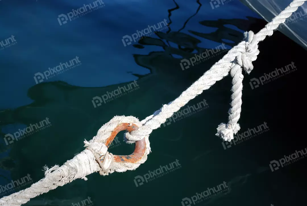 Sturdy Boat Mooring Rope and Rusty Metal Ring in Deep Blue Water