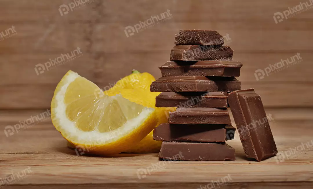 Stacked Chocolate Bars with Fresh Lemon Slices on Rustic Wood