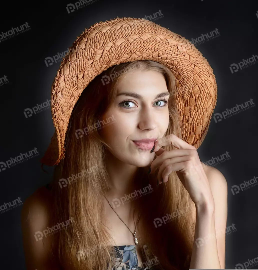Charming Blonde Woman in Straw Hat with Finger on Lips