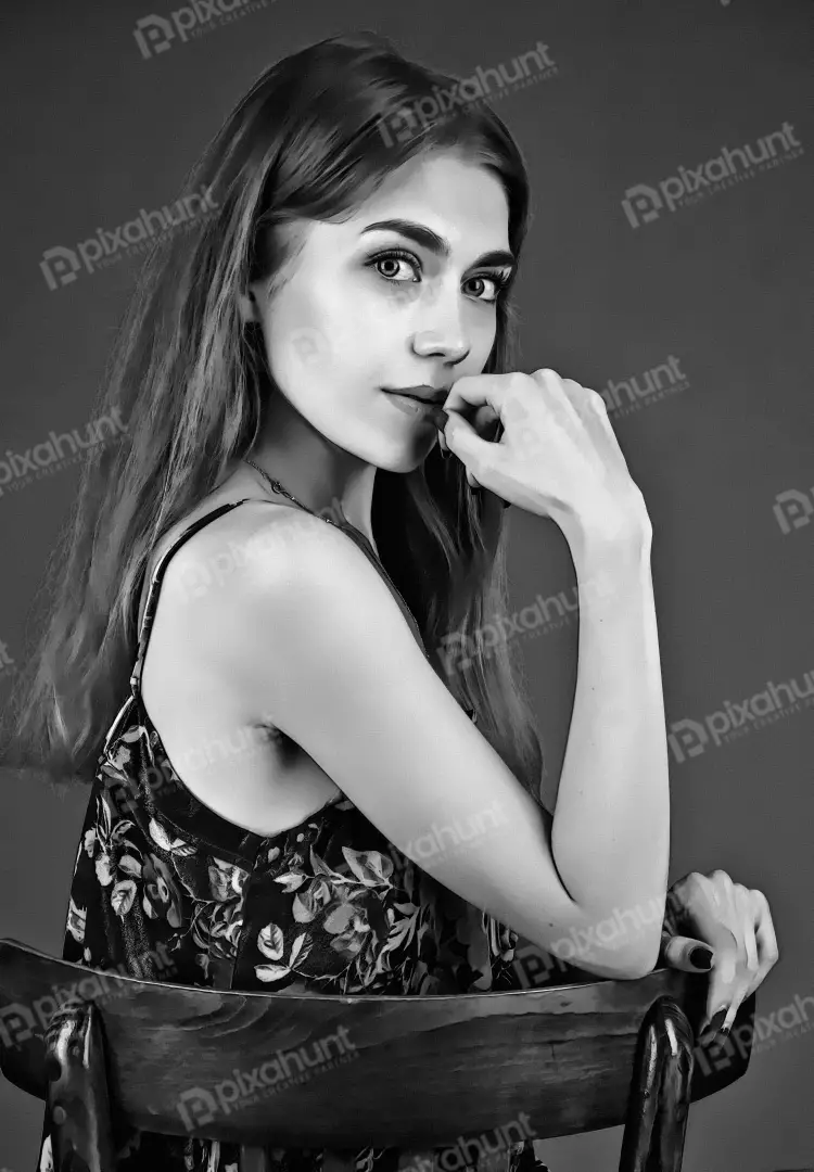 Pensive Young Woman Posing Elegantly on Chair Black and White Portrait
