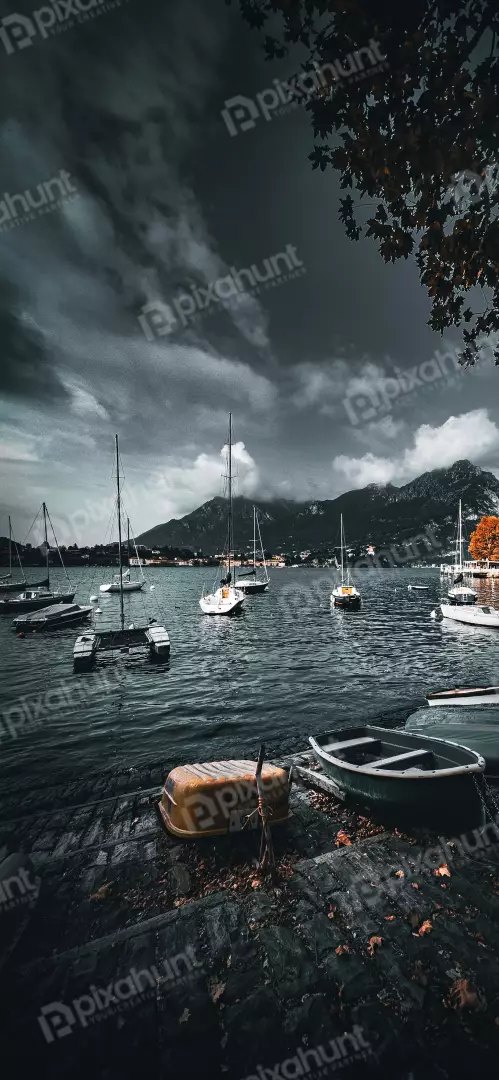Free Premium Stock Photos Sailboats Moored on a Lake Under Dramatic Cloudy Sky with Autumn Foliage