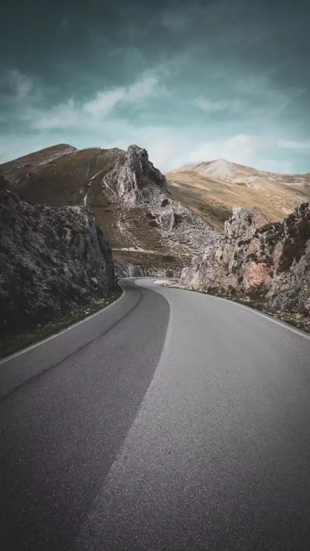Free Premium Stock Photos Winding Mountain Road Through Rocky Landscape Under Cloudy Sky