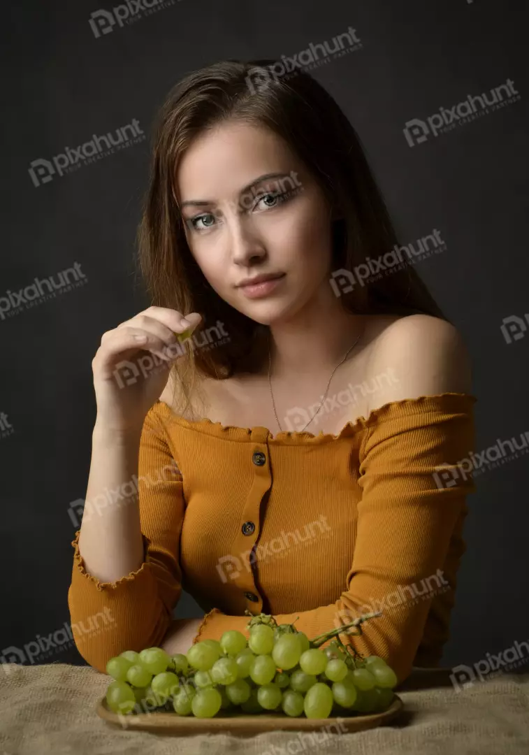 Captivating Woman in Off-Shoulder Top Posing with Fresh Green Grapes