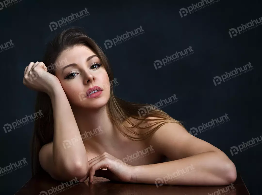Pensive Woman with Long Brown Hair Resting Head on Hand