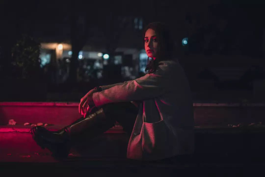 Free Premium Stock Photos Woman Sitting Outdoors at Night with Red Lighting