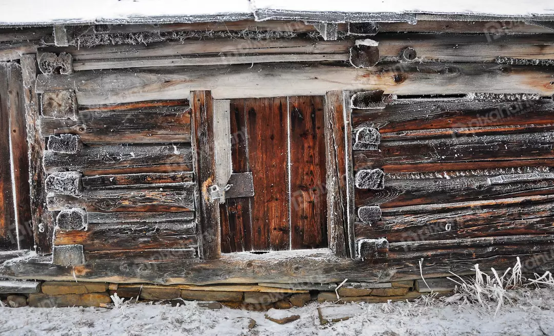 Rustic Frosted Log Cabin Wall in Winter with Wooden Door