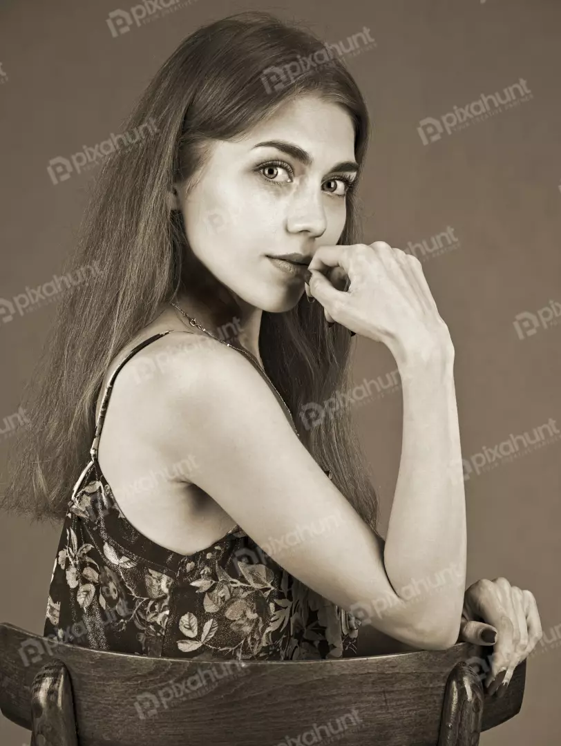 Vintage Sepia Portrait: Thoughtful Young Woman with Hand on Chin
