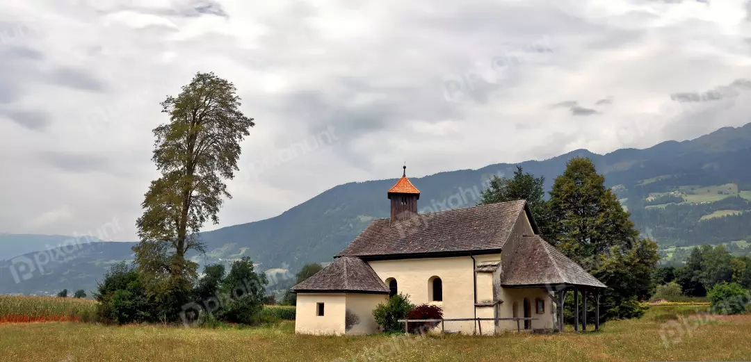 Historic Rural Church Bell Tower Amidst Lush Mountain Landscape