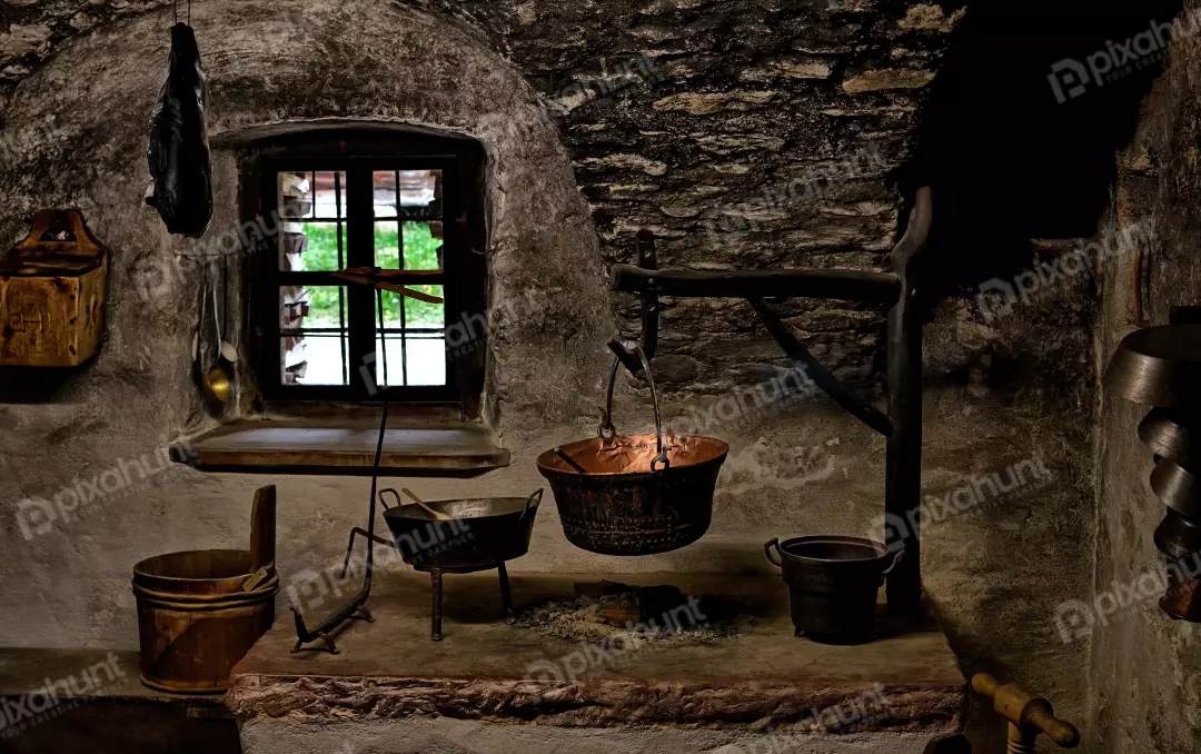 Rustic Stone Kitchen Hearth with Antique Copper Pots and Window View