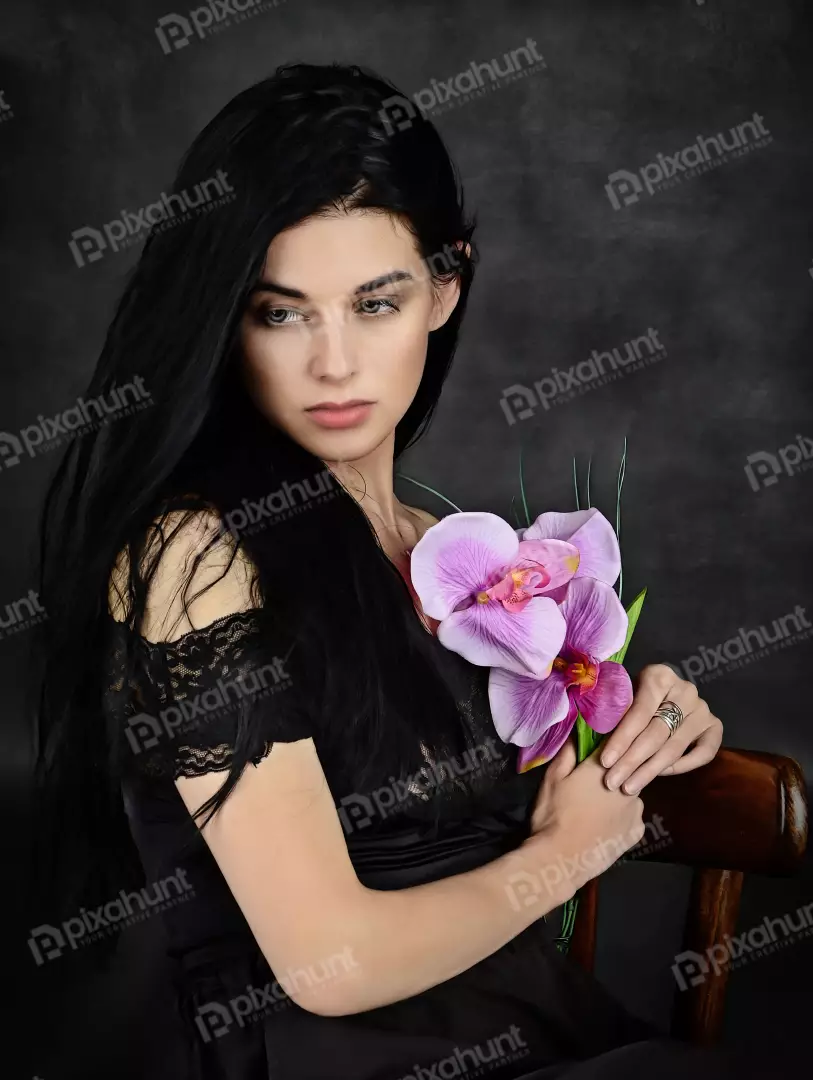 Pensive Woman with Long Dark Hair and Purple Orchids Portrait
