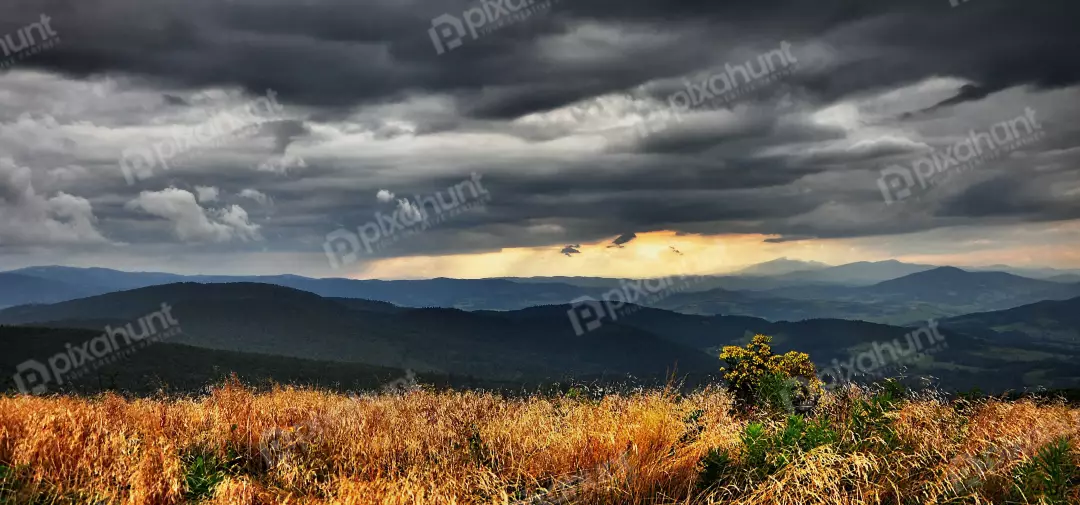 Dramatic Mountain Landscape with Golden Sunset Sky and Storm Clouds
