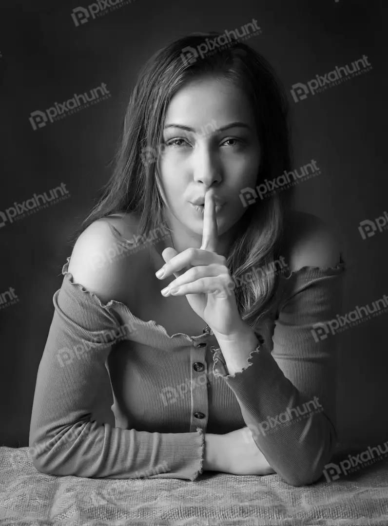 Young Woman Signaling Silence in Monochrome Portrait