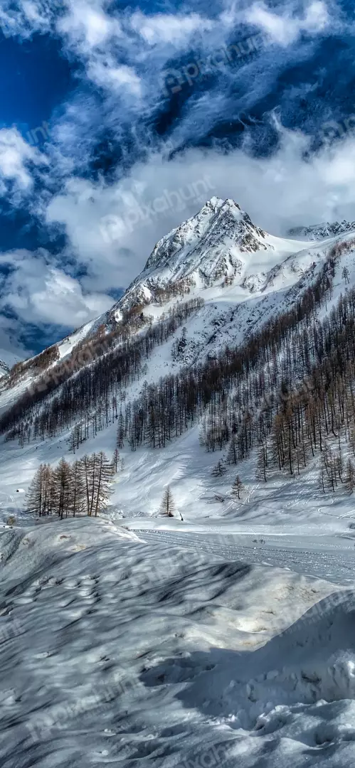 Free Premium Stock Photos Majestic snow-capped mountain peak under a dramatic blue sky with clouds