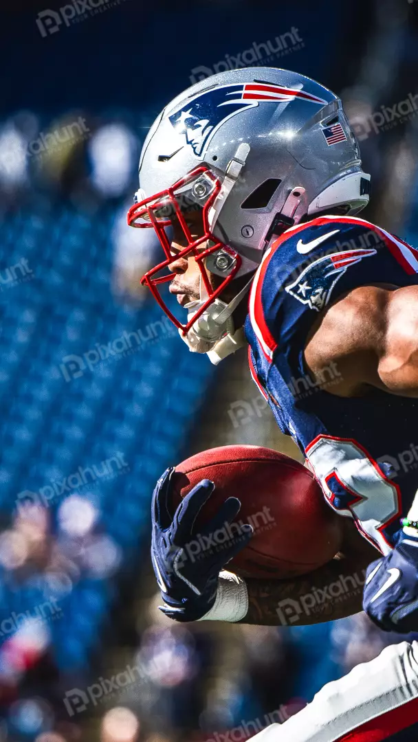 New England Patriots player carries the football during a game