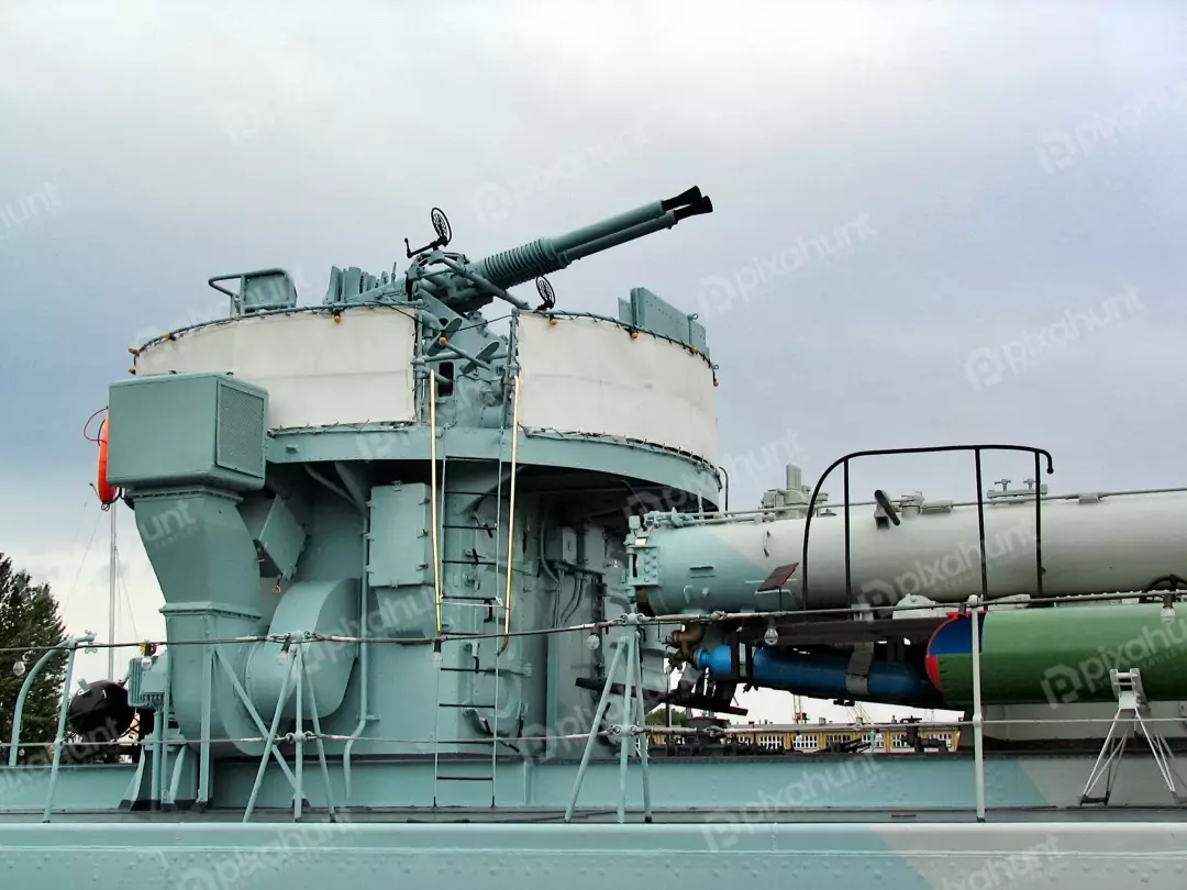 Naval Anti-Aircraft Gun and Torpedo Launcher on Warship Deck Under Grey Sky