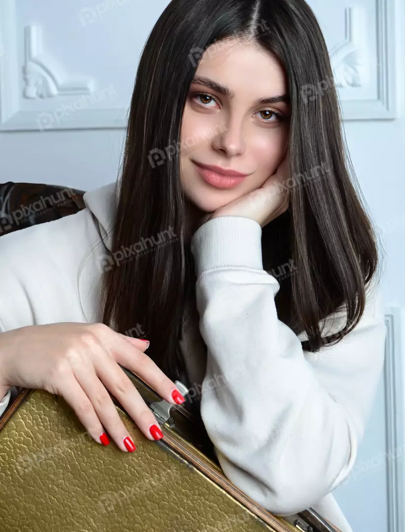 Beautiful Young Woman Leaning with Hand on Chin Looking at Camera in a Casual Pose