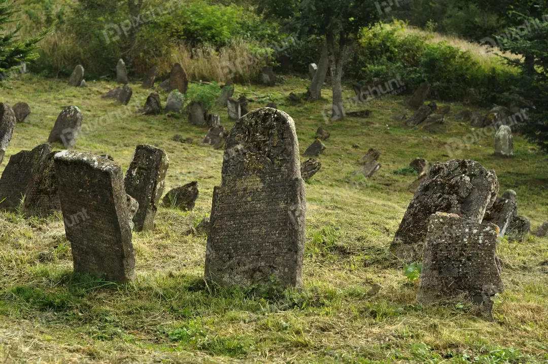Ancient Moss-Covered Gravestones on a Grassy Hillside in a Serene, Historic Cemetery