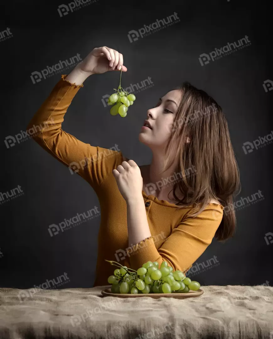 Young Woman Thoughtfully Holding Green Grapes, Healthy Eating Still Life
