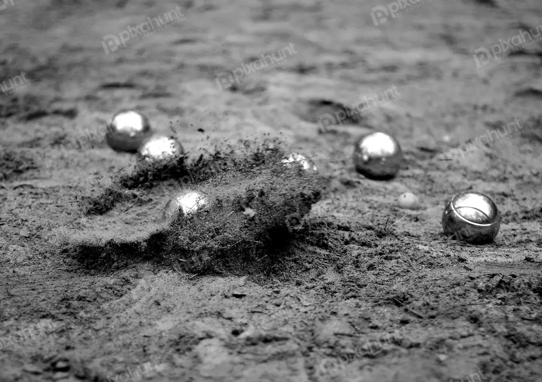 Dynamic Black and White Pétanque Game with Metal Boules Kicking Up Dust