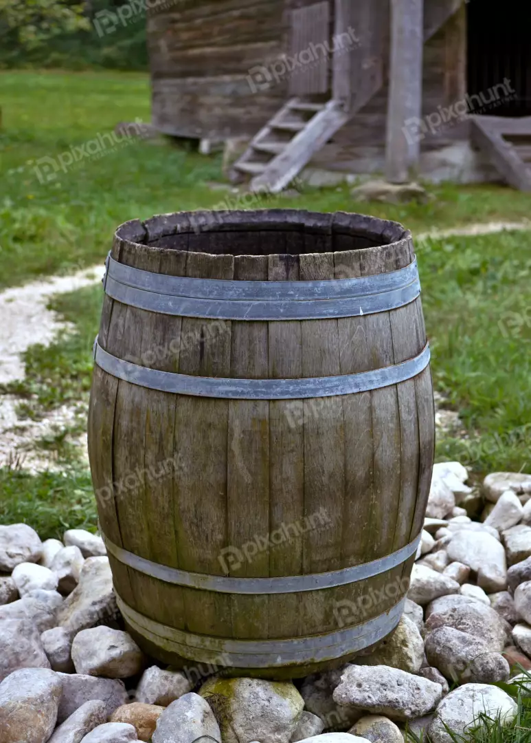 Rustic Wooden Barrel in Rural Landscape with Old Building and Stones