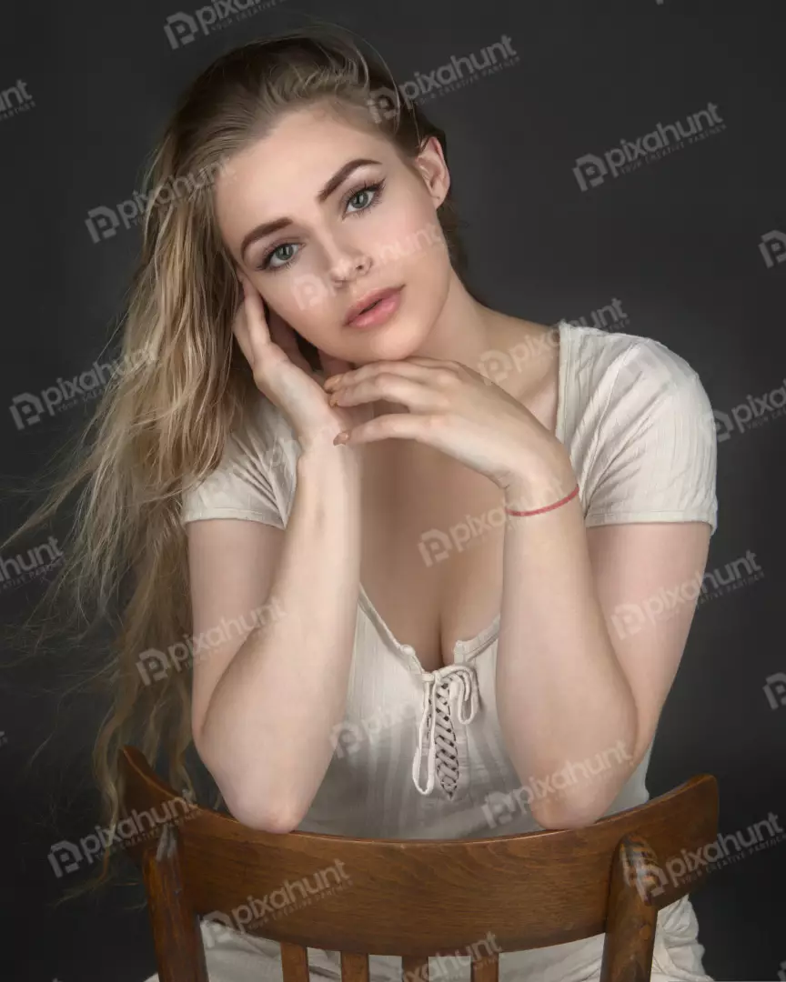 Serene Blonde Woman Portrait with Delicate Hand Pose on Wooden Chair