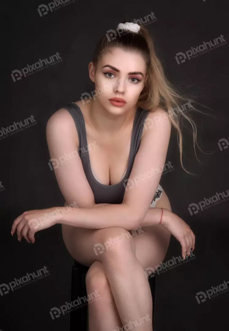 Pensive Blonde Woman Posing in Grey Top with High Ponytail
