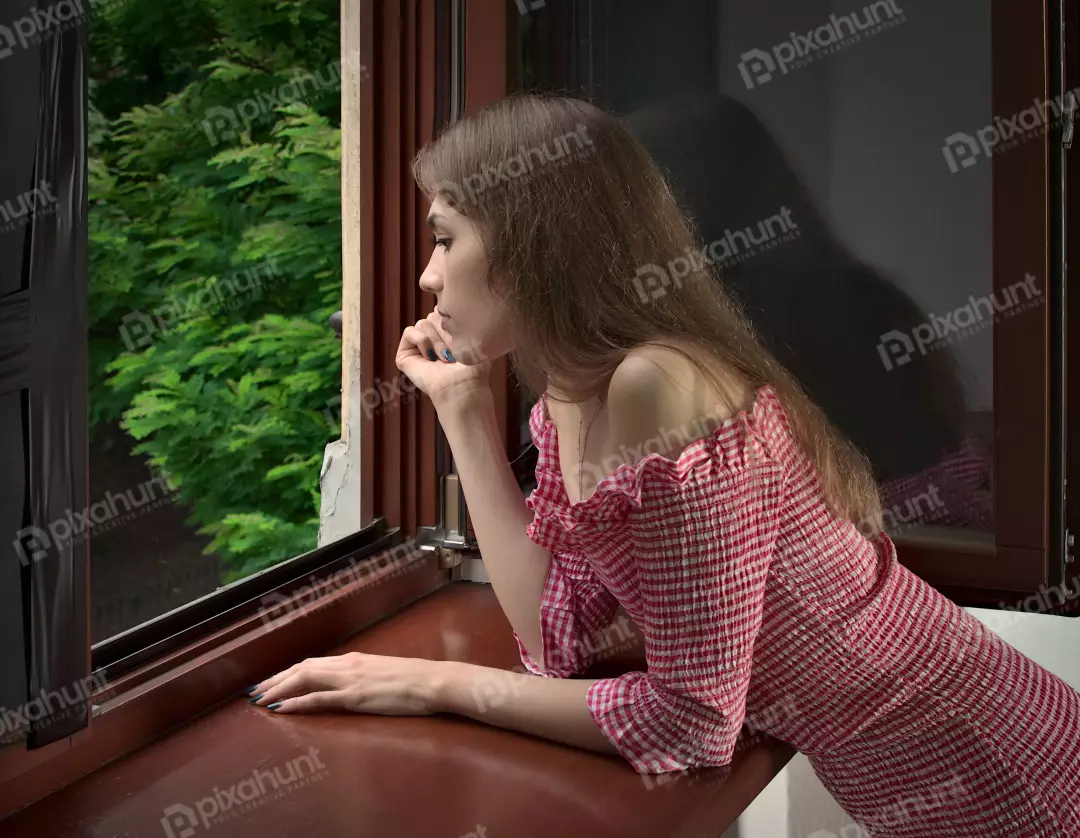 Young Woman in Red Gingham Dress Gazing Out Window at Greenery Looking outside