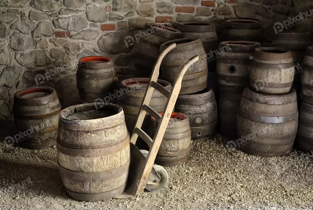 Rustic Wine Cellar with Old Wooden Barrels and Vintage Hand Truck