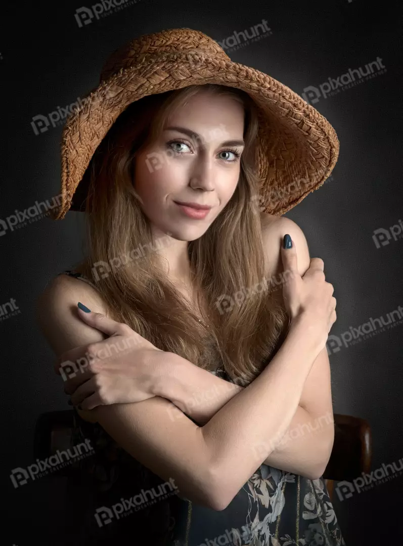 Smiling Young Woman in Straw Hat Posing with Crossed Arms for Portrait