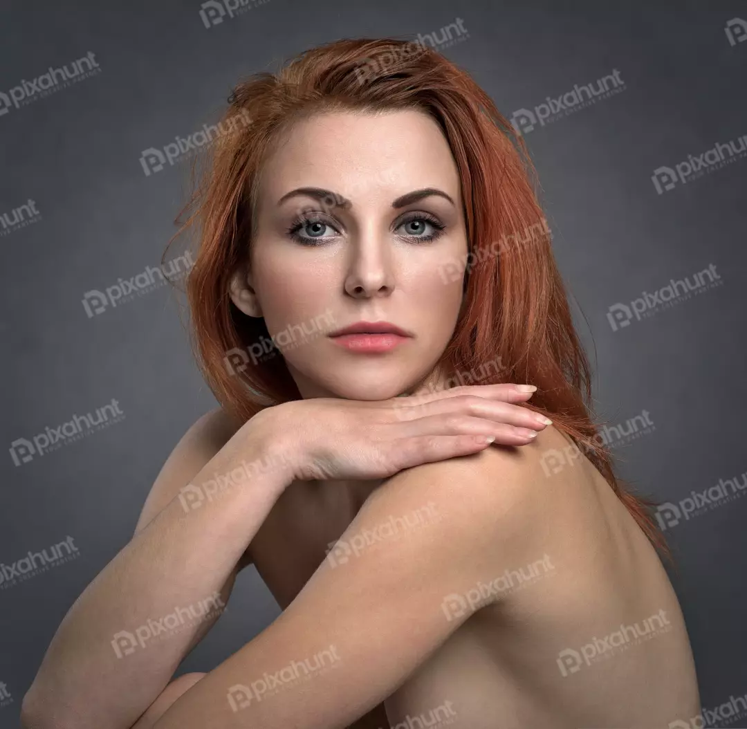 Captivating Redhead Woman Posing with Bare Shoulders in Studio Portrait