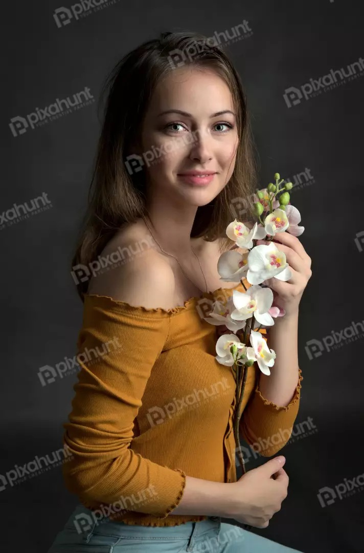 Young Woman Posing with Elegant Orchids, Smiling Candidly for Portrait