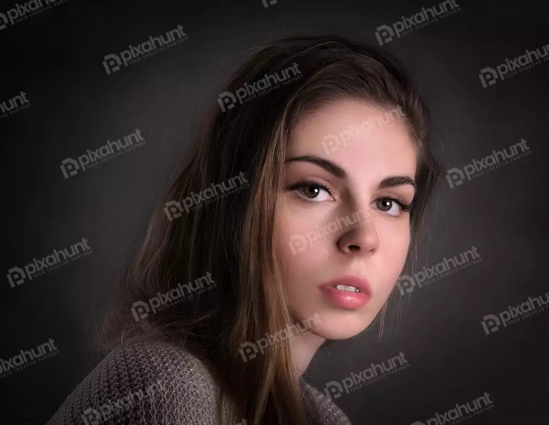 Young Woman Headshot with Long Brown Hair and Contemplative Gaze