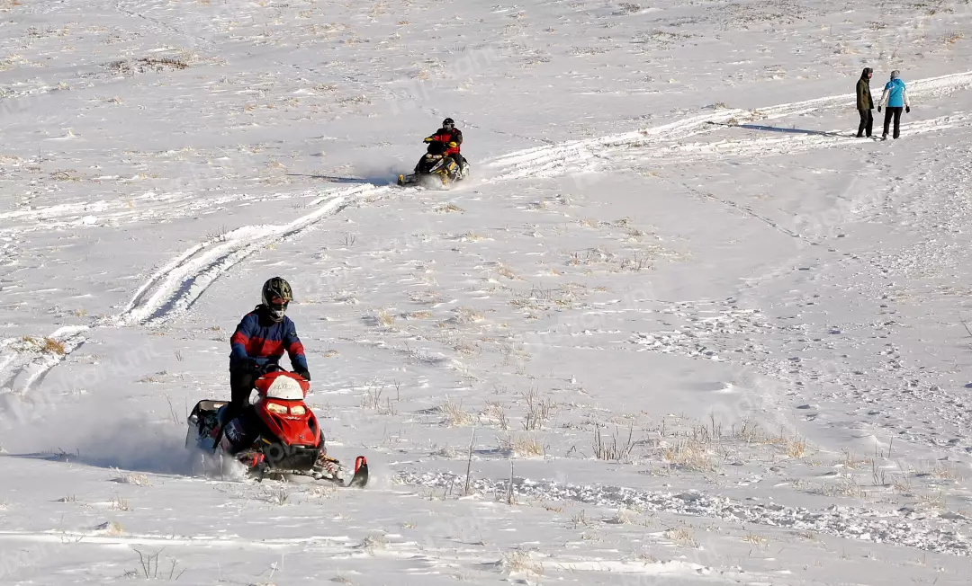 People Enjoying Snowmobiling and Winter Sports on a Sunny Snowy Landscape Adventure