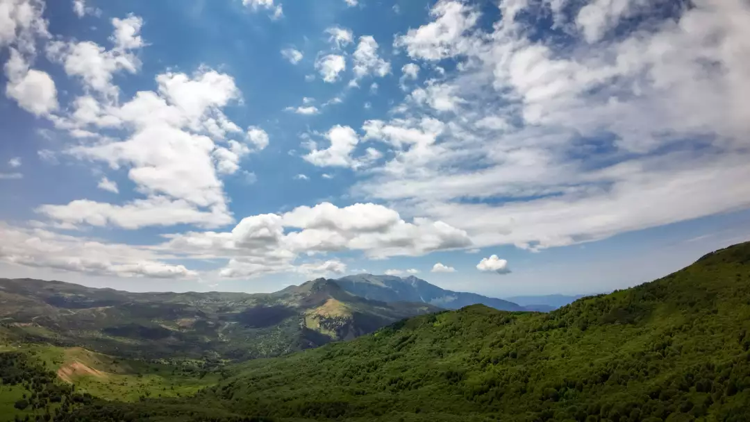 Free Premium Stock Photos Expansive mountain landscape with lush green forests under a partly cloudy sky