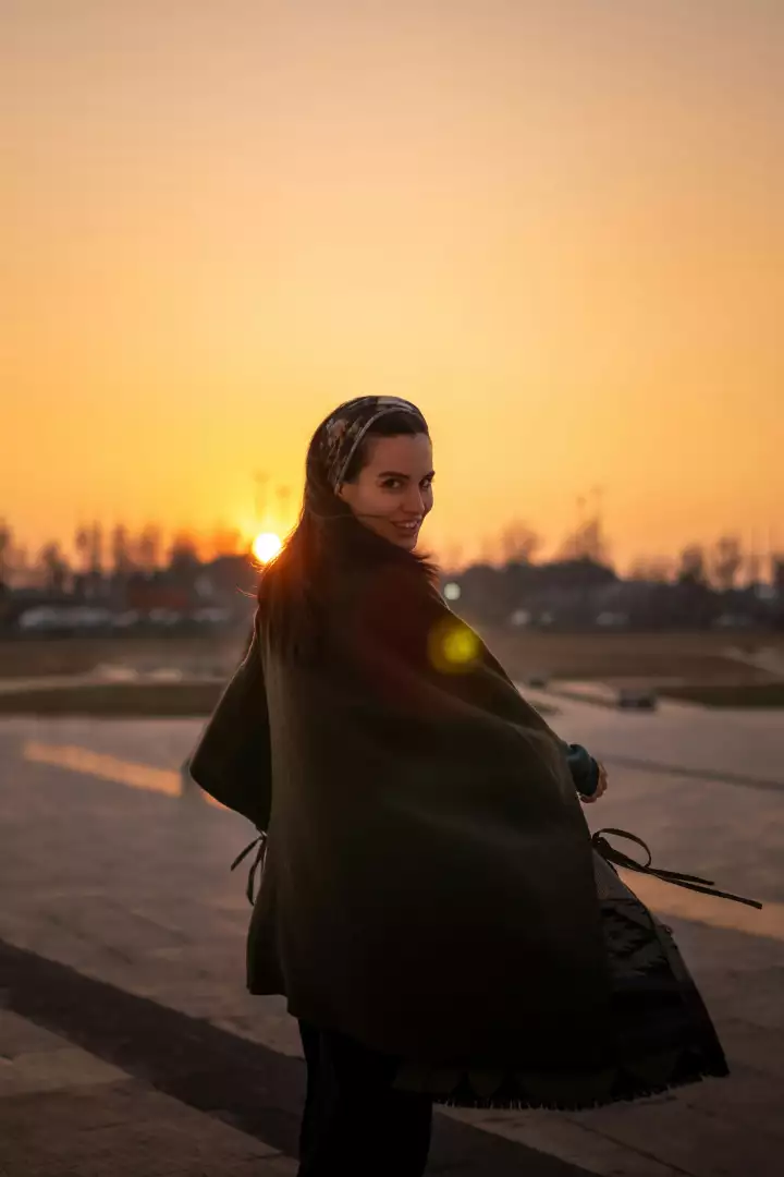 Free Premium Stock Photos Young woman smiling at sunset wearing a headscarf and shawl