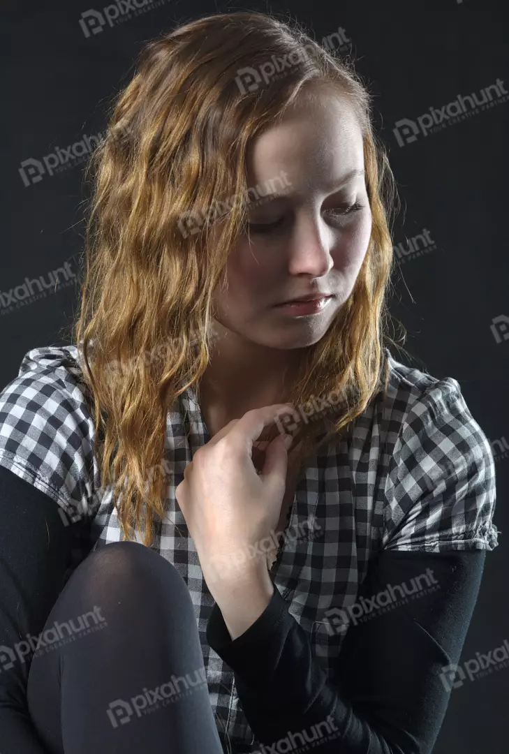 Pensive Young Woman with Wavy Hair in Checkered Shirt Reflecting on Deep Emotions