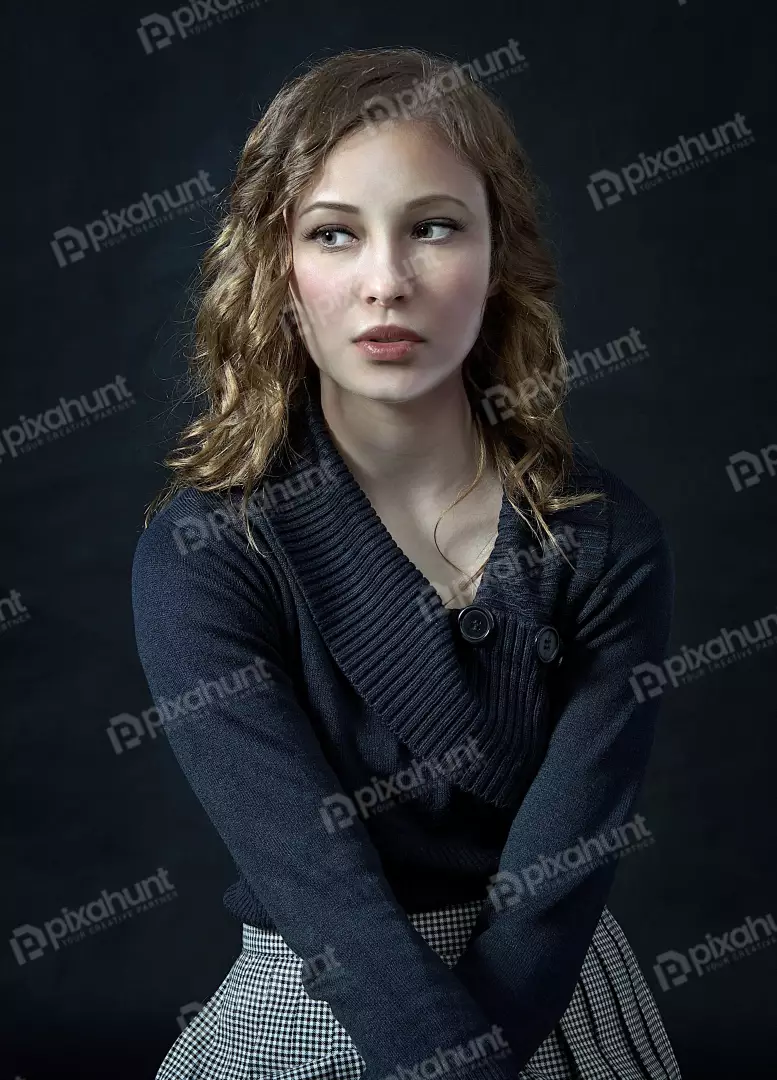 Young Woman with Curly Hair and Pensive Gaze in Studio Portrait